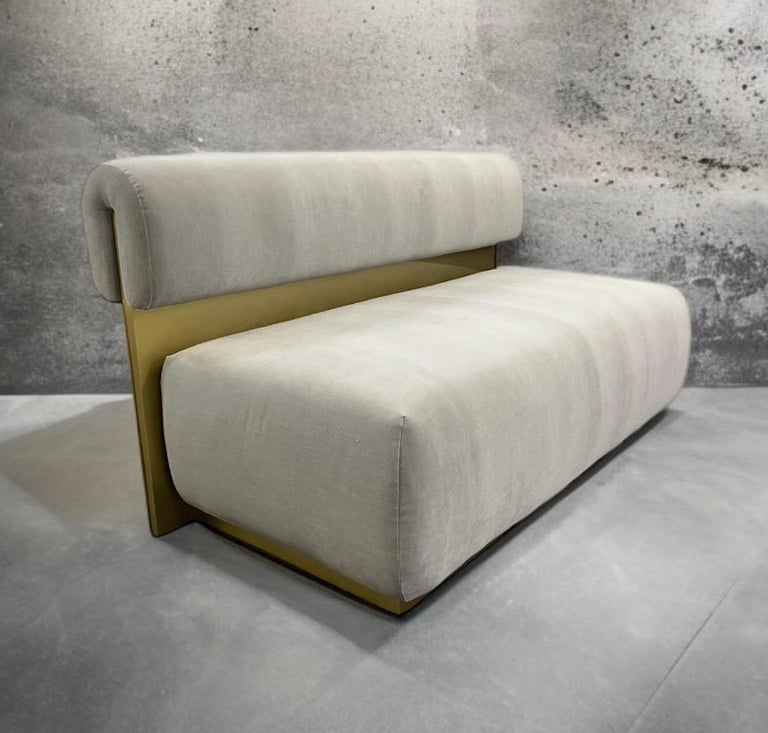 Modern bench with plush cream cushions and gold metal back, by Solo Home Decor.
