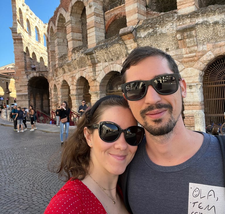 a man and woman standing in front of colosseum