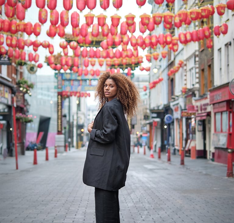 ensaio fotográfico urbano com mulher posando em rua decorada com lanternas orientais