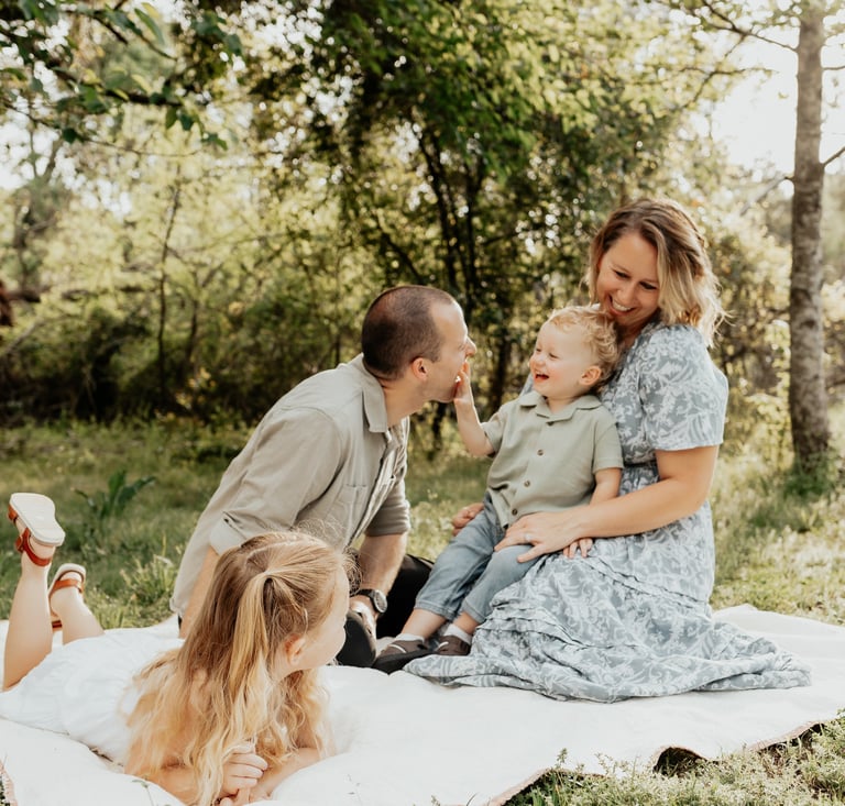 a family of four sitting on a blanket