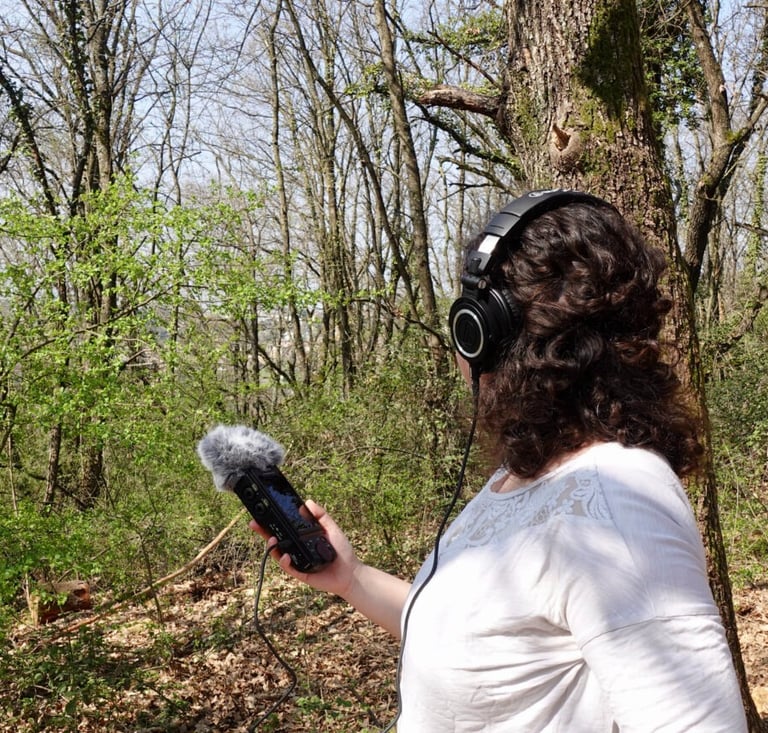 Federica doing some field recording in nature with headphones and a microphone