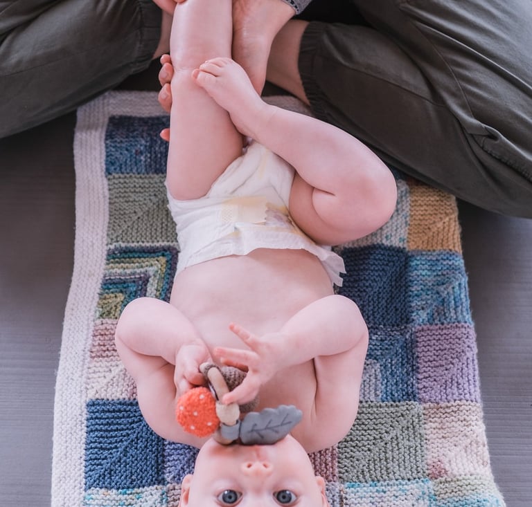 Baby stretching with parent during Rock & Roll Baby yoga in Radwinter near Saffron Walden