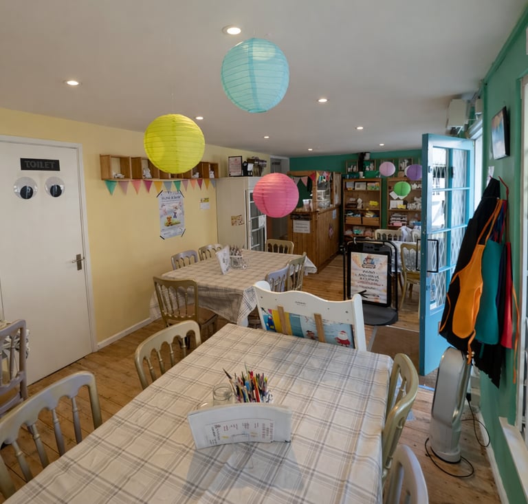 Inside The Crafty Beanie toddler craft class studio in Saffron Walden with tables set up for pottery painting and crafts.