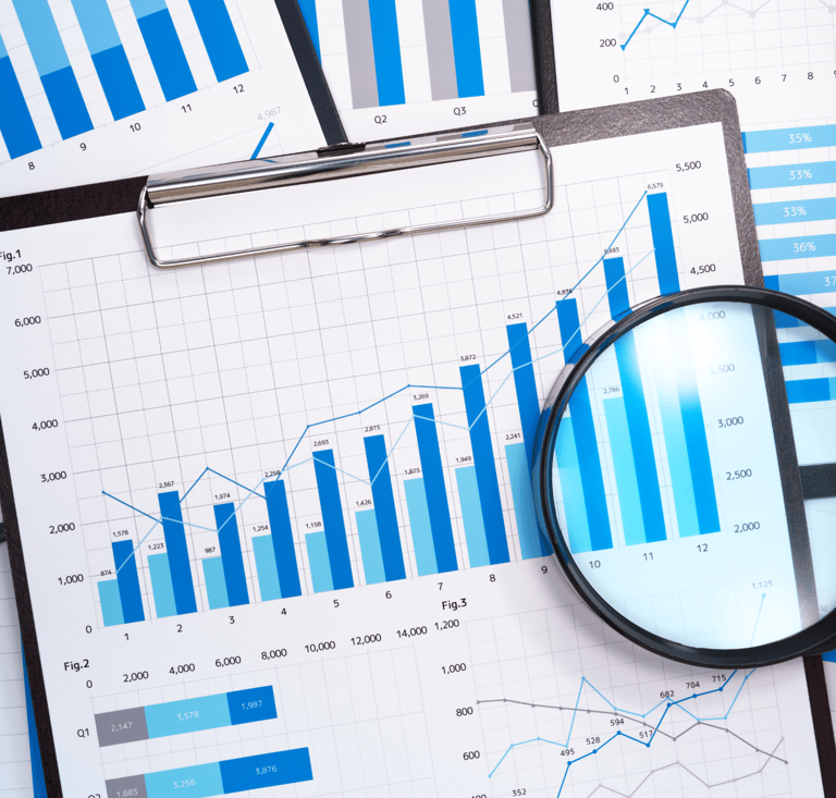 a magnifying glass over a graph on a clipboard