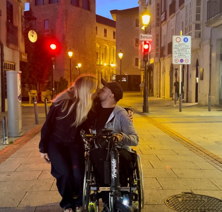 a man and woman kissing on a city street