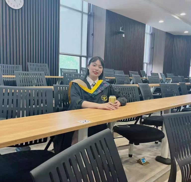 a woman in a graduation gown standing in front of a row of chairs