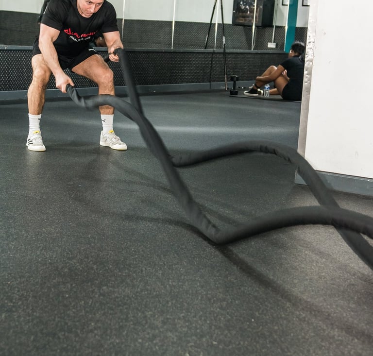 a man is holding a rope rope in a gym