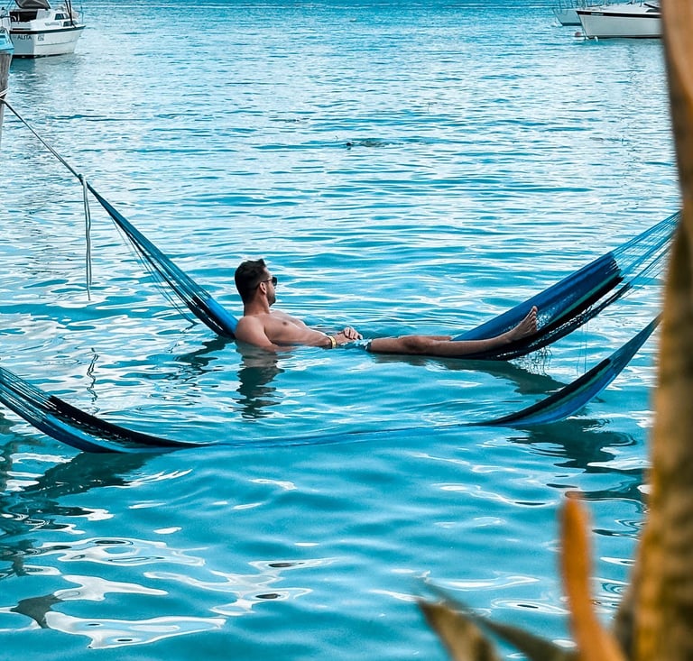 Mann in Hängematte im Wasser Bacalar Mexiko Beachclub