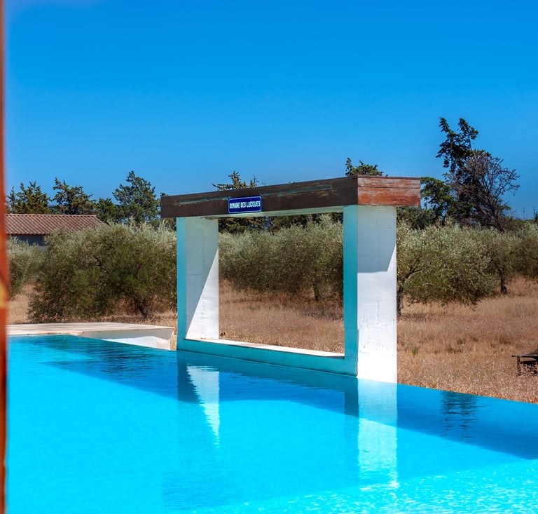 Swimming pool with beach chairs, wide view and waterfall cascade built-in at Domaine Des Lucques