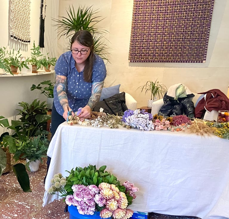 a woman is standing in front of a table with flowers