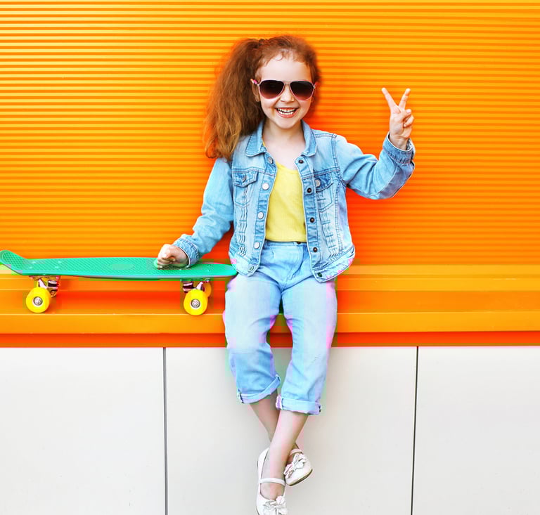 LIttle girl with stylish sunglasses holding up a peace sign