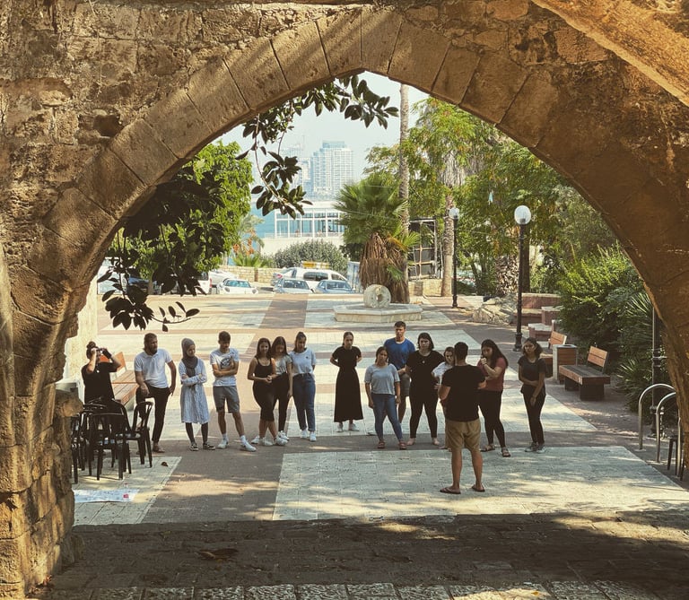 a group of people standing around a stone arch