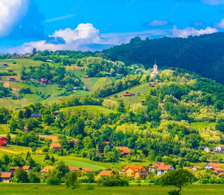 Prekrasan pogled na krajolik Zagorja. U brdima se vide malene kućice i crkva.