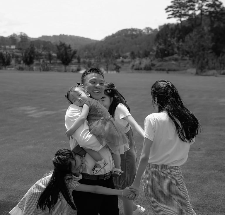 a family of four people standing around a woman holding a baby