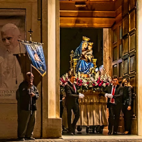 Carrying of a statue of Our Lady next to picture of the pope