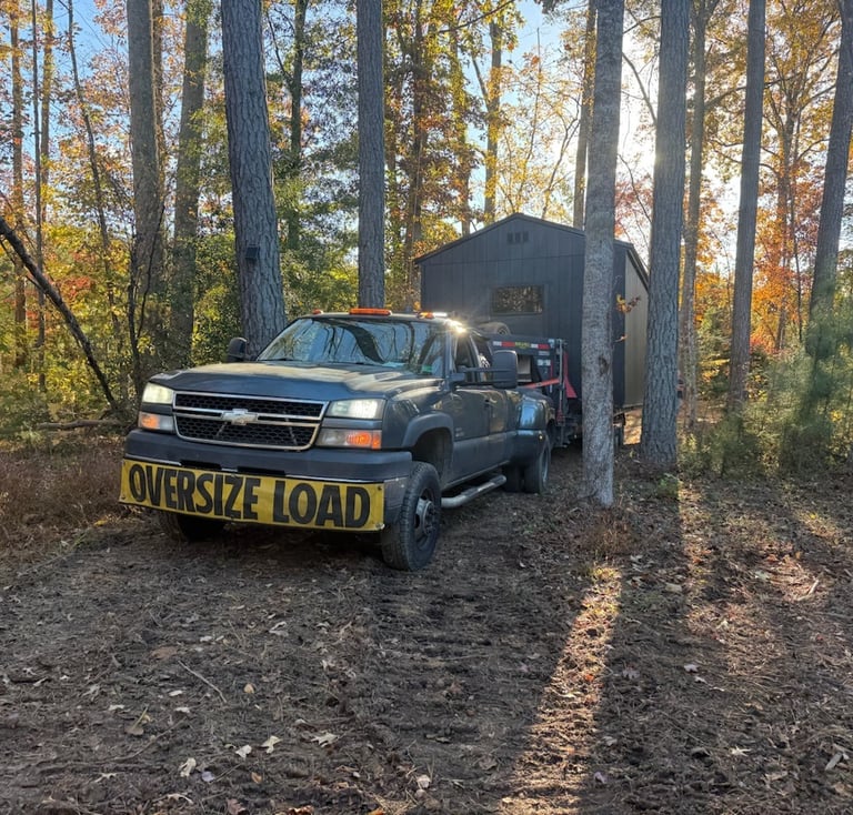 Shed on a trailer in the woods being delivered