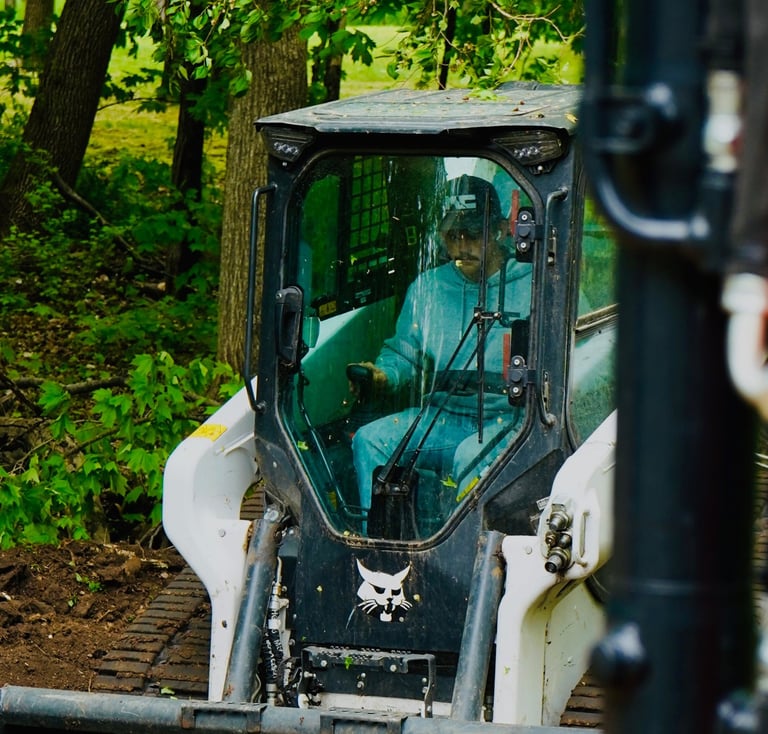 Owner, Patrick Kruse, in a bobcat skid steer grading dirt