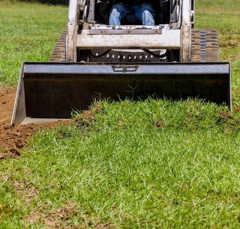 skid-steer-clearing-dirt-with-bucket-attachment.jpg