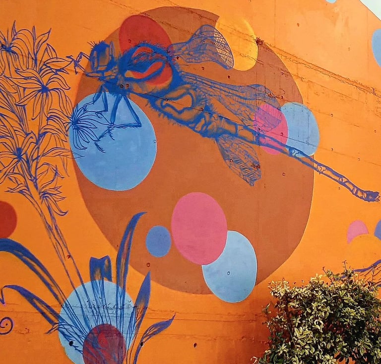 une fresque d'une libellule bleu sur fond orange