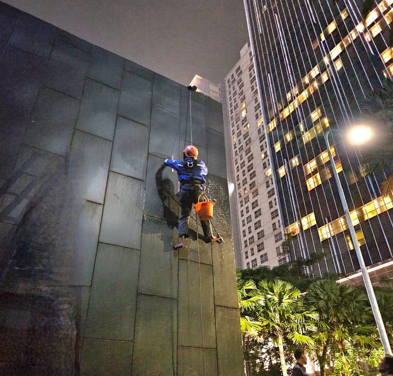 a man on a rope rope with a bucket on a building