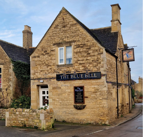 a rural stone building with a sign that says the blue bell