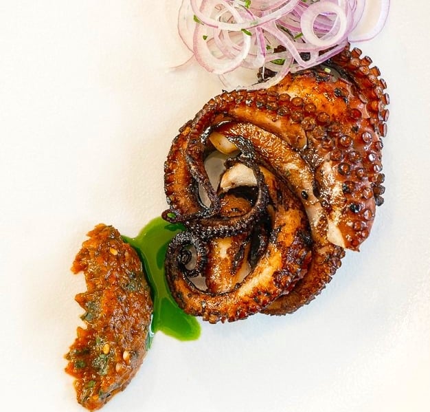 Grilled octopus with dried tomato-herbs sauce & basil oil - prepared by Villa Eats in Naxos