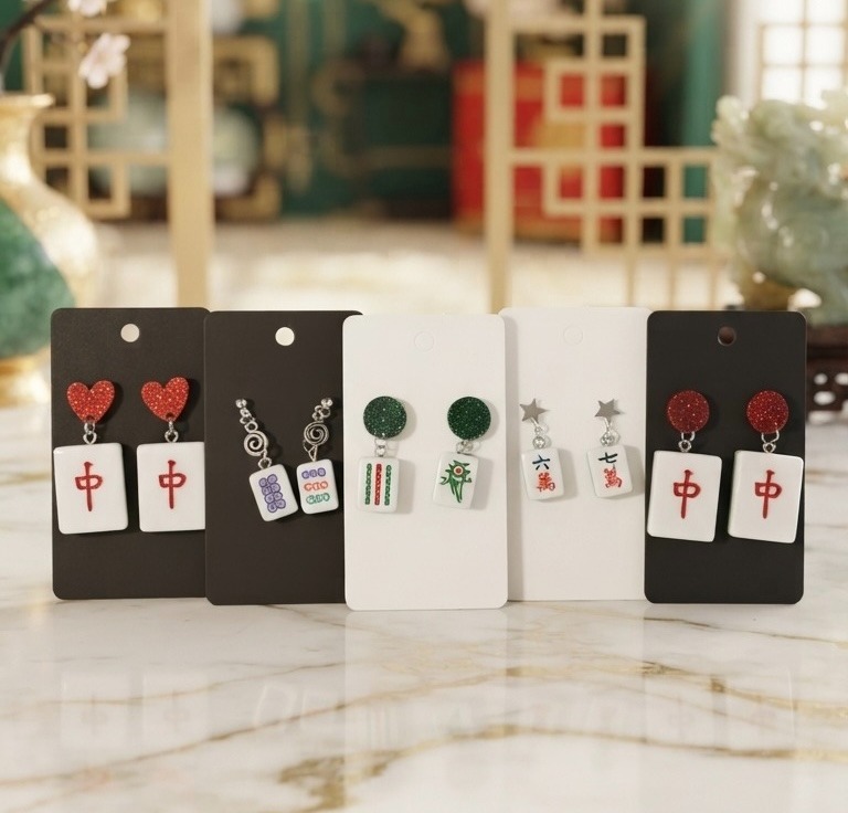 A collection of earrings made out of mahjong tiles in red, green and blue