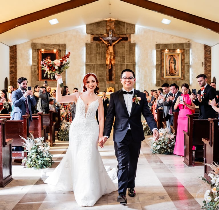 a bride and groom walking down the aisle of a church