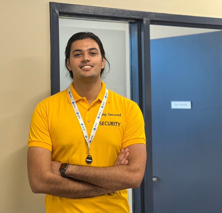 A male employee of Baig Security standing beside a door