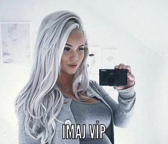 a woman with long hair and a camera taking a selfie