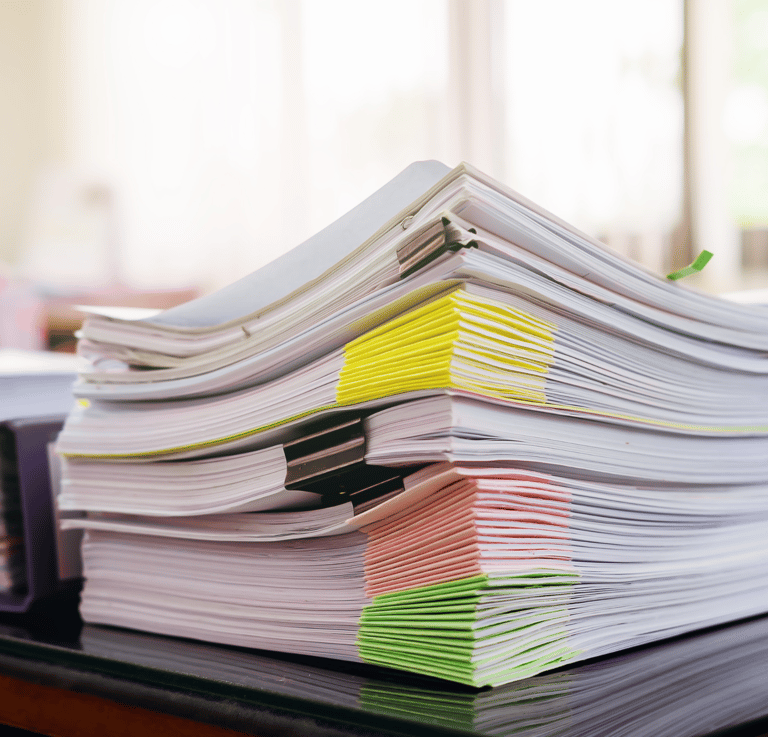 a stack of papers on top of a desk