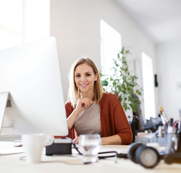 Young professional administrative assistant at her desk in her office.