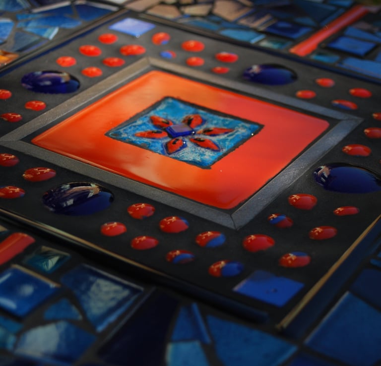 a table with a colorful glass tile and a red and blue tile