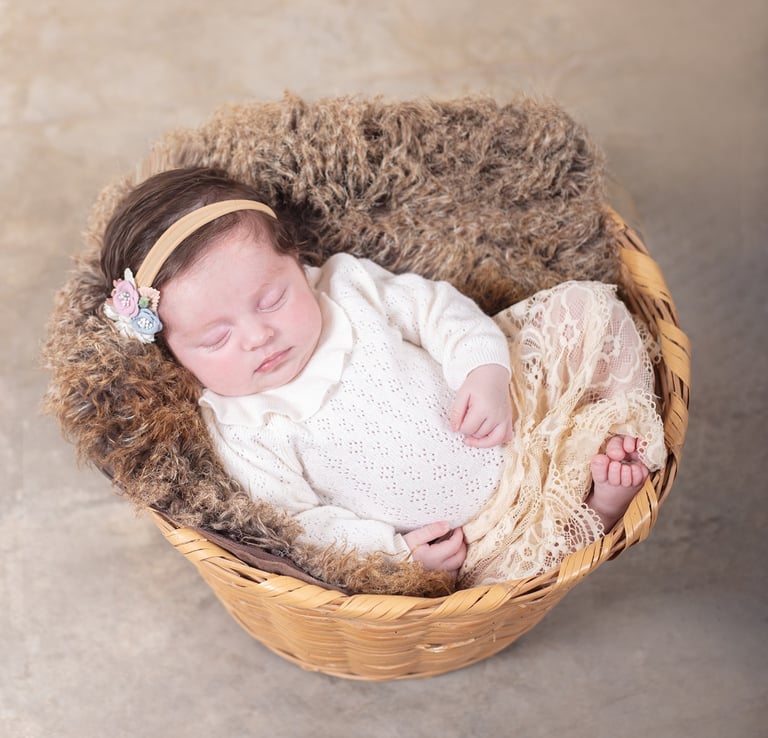 una bebé dormida en un cesto de paja
