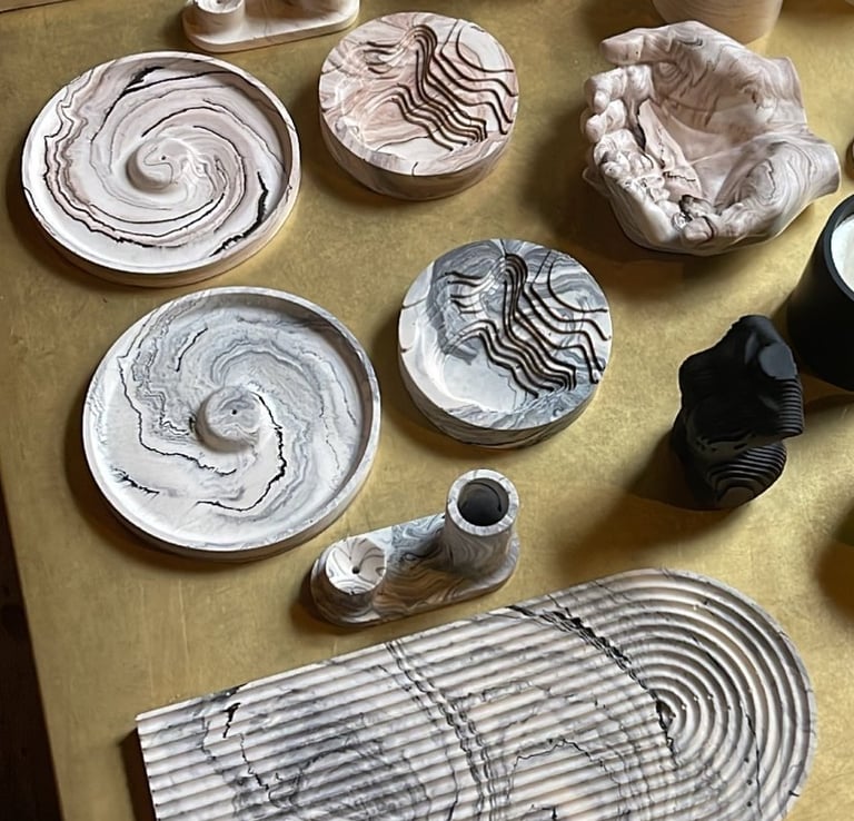 a table with a lot of different types of jesmonite pieces and candles
