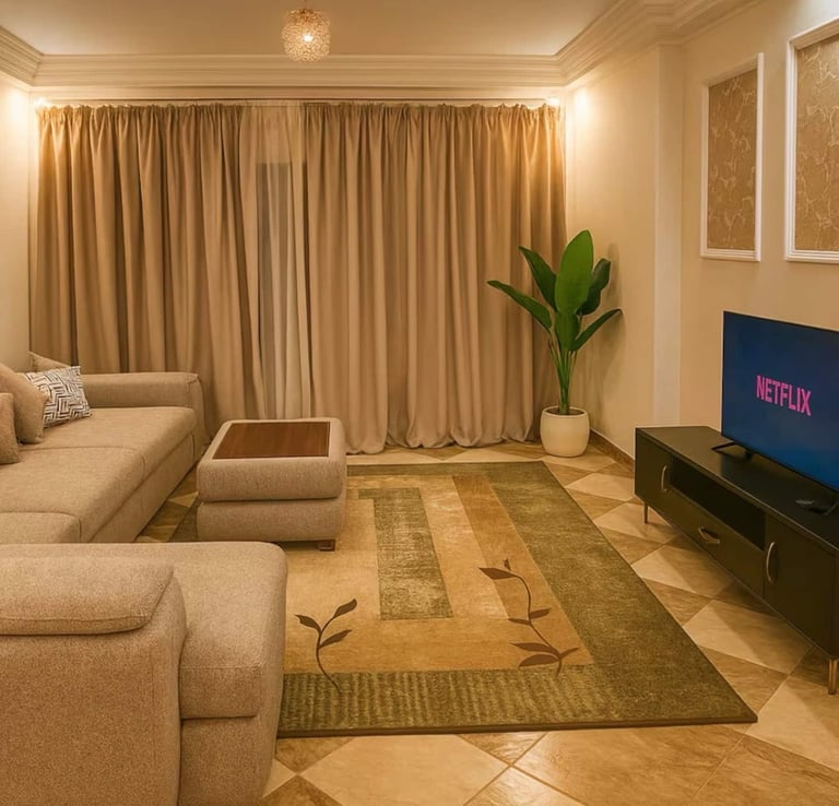 Modern living room with a beige sectional sofa, patterned area rug, and smart TV displaying Netflix.