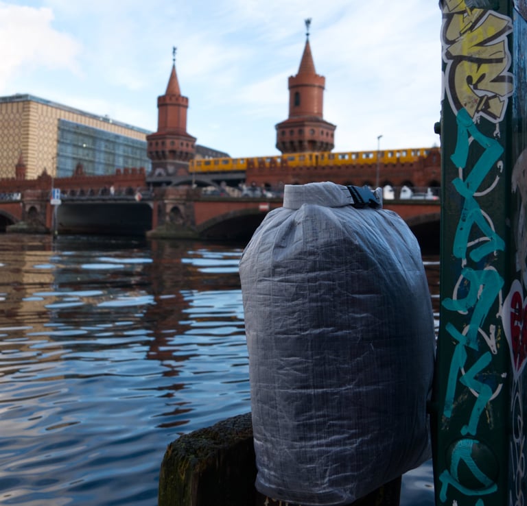 A dyneema dry bag and a train crossing a bridge in the background