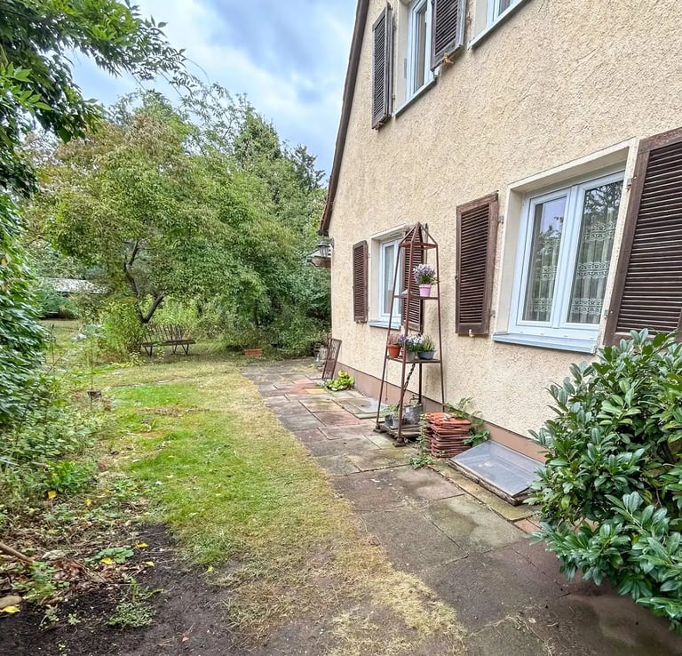 Seitlicher Gartenbereich einer Doppelhaushälfte mit gepflegtem Grün und Terrasse.