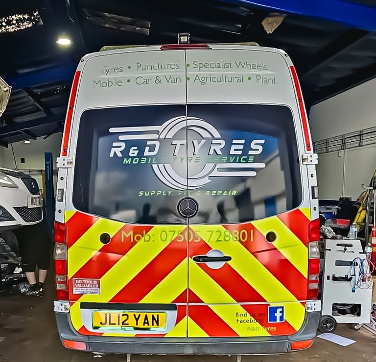 R&D Tyres mobile tyre service van with yellow and red chevrons parked in a garage for repairs.