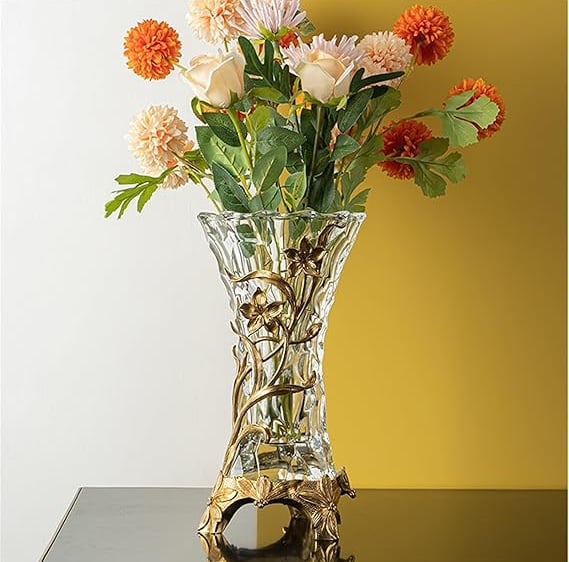 Ornate crystal vase with gold inlay patterns filled with fresh flowers, high-end decorative piece.