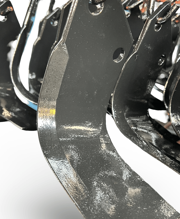 Durable black steel rotary tiller blades and cultivator tines for agricultural soil preparation.