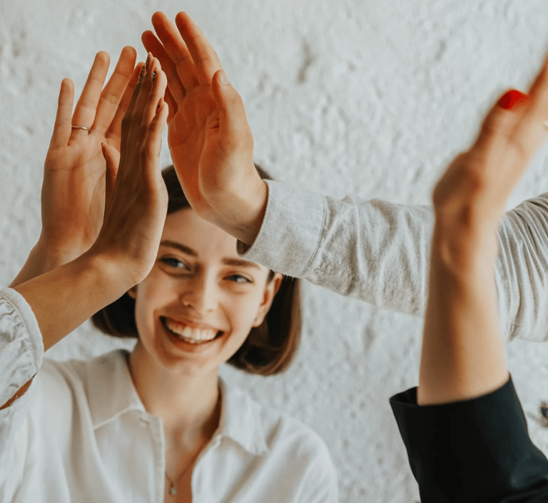 a woman is giving a high five finger sign