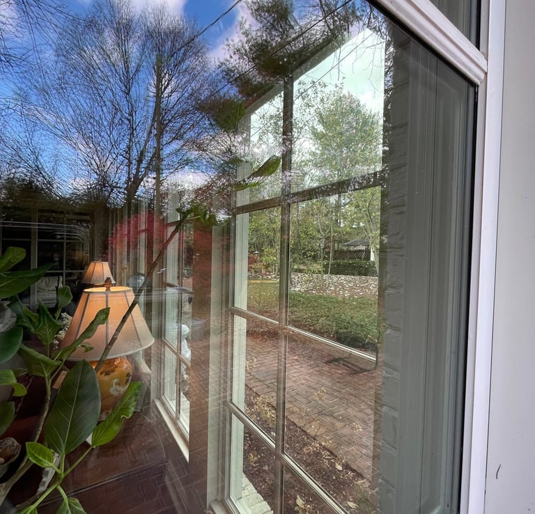 a window with a clear view of a patio with a couch and a lamp
