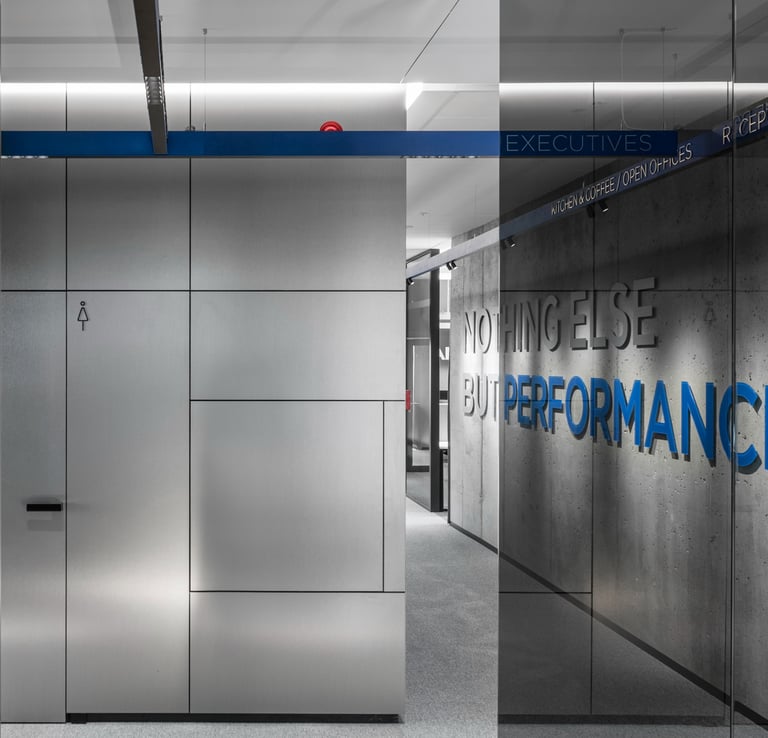 Modernus biuro interjeras Vilniuje, Manvesta, šlifuotas plienas, stiklas, betono siena su šūkiu