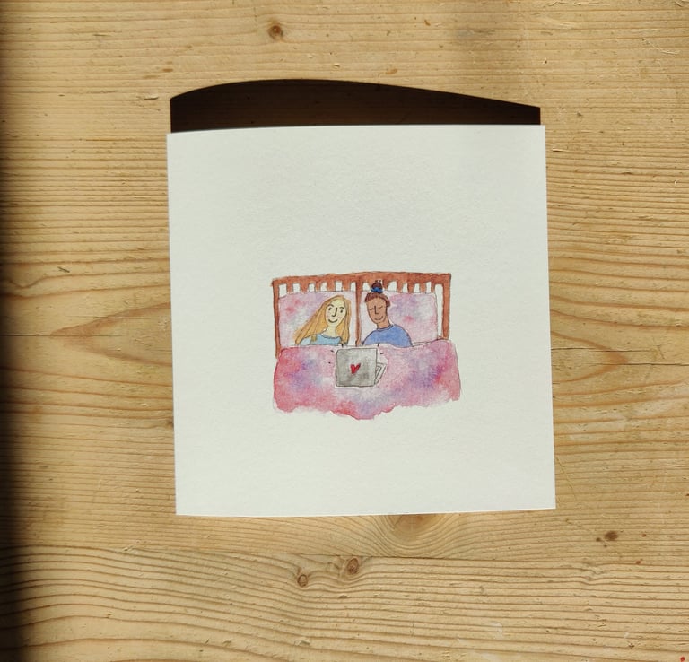 a queer greetings card of a queer couple in bed watching tv on a laptop.