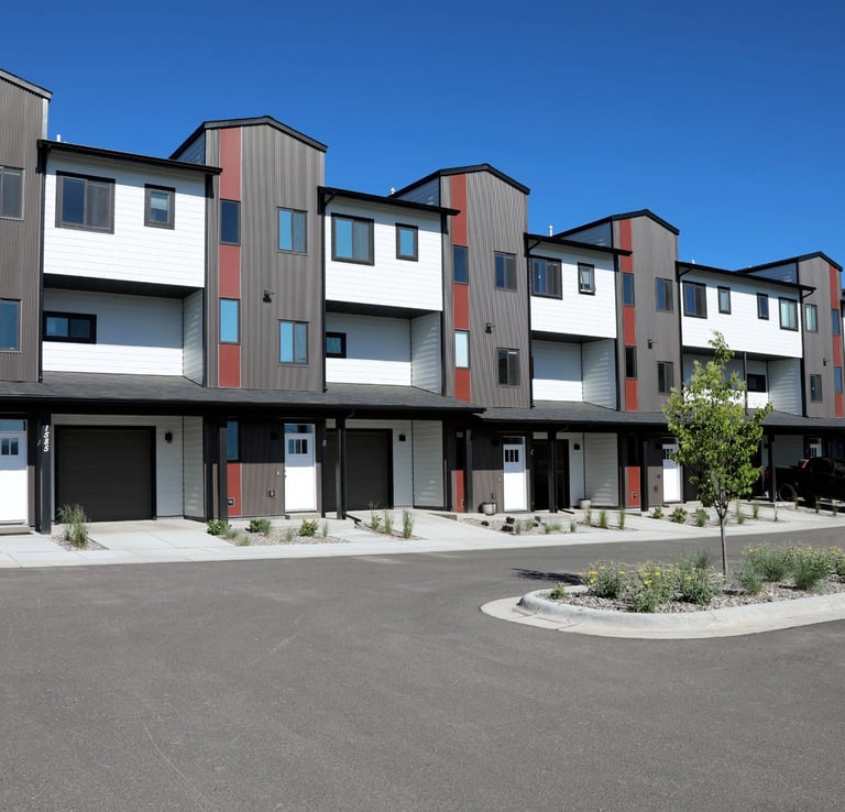 a row of apartment buildings with a parking lot