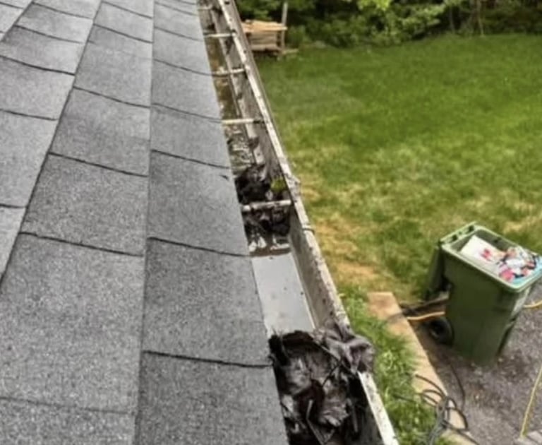 Gouttières pleines de feuilles entrain de se faire déboucher