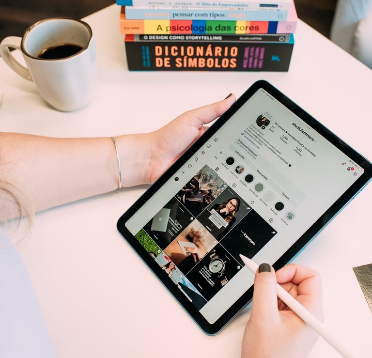 Pessoa usando tablet com caneta digital para navegar nas redes sociais em uma mesa de trabalho.