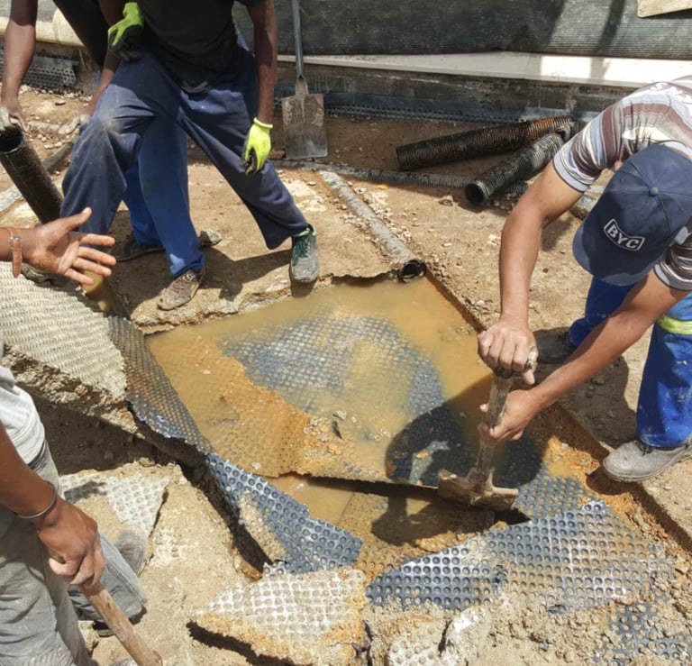 Engineers inspecting damaged concrete slab for water ingress