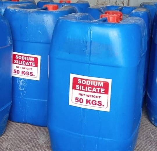 a group of blue plastic barrels with red and white labels filled with liquid sodium silicate